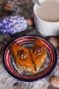 Assorted baklava. A Turkish ramadan arabic sweet dessert on a decorative plate, with coffee cup in the background Royalty Free Stock Photo