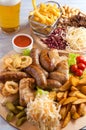 Assorted beer snacks: chicken wings, grilled sausages, potatoes, nuts, cheese, croutons Royalty Free Stock Photo