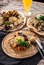 Assorted beer snacks smoked fish, cheese, roastbeef, bread croutons on wooden platter and glass of beer