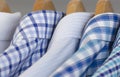 Assorted blue dress shirts on wooden hangers Royalty Free Stock Photo