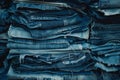 Assorted blue jeans are piled high, displaying various shades of denim, with frayed Royalty Free Stock Photo