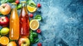 Assorted bottles of fruit juice with fresh fruits on a textured blue background. Royalty Free Stock Photo