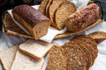 Assorted bread slices in a basket on a white linen tablecloth