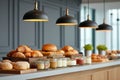 Assorted breakfast pastries and bread with jars of jam and cream on counter under warm lights in modern buffet setting Royalty Free Stock Photo
