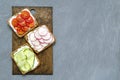 Assorted breakfast sandwiches with a slice of whole grain dark bread cream cheese cucumbers radishes cherry tomatoes on Royalty Free Stock Photo