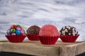 Assorted brigadeiros on wooden board with multicolored background