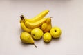 Assorted bright yellow fruits. Fresh banana, pear, apple, lemon. Harvest on a stone background Royalty Free Stock Photo
