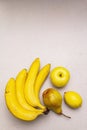 Assorted bright yellow fruits. Fresh banana, pear, apple, lemon. Harvest on a stone background Royalty Free Stock Photo