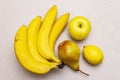 Assorted bright yellow fruits. Fresh banana, pear, apple, lemon. Harvest on a stone background Royalty Free Stock Photo