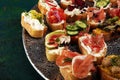 Assorted bruschetta with various toppings. Appetizing bruschetta or brie crostini. Variety of small sandwiches. Mix bruschetta on Royalty Free Stock Photo