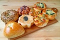 Assorted buns and pastries on wooden tray served on wooden table Royalty Free Stock Photo