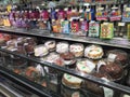 Assorted birthday cakes and candles for sale displayed supermarket bakery section in refrigerated case