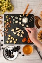 Assorted with cheese , fruits and nuts on the black stone with woman hand Royalty Free Stock Photo