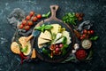 Assorted cheeses on a plate. Parmesan cheese, blue cheese and brie on a plate with grapes and figs. Antipasto. Top view Royalty Free Stock Photo