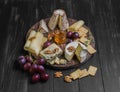 Assorted cheeses on round wooden board plate Royalty Free Stock Photo