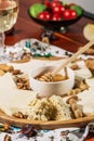 Assorted cheeses on round wooden board plate served with white wine Guda cheese, cheese grated bark of oak, hard cheese slices, Royalty Free Stock Photo