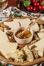 Assorted cheeses on round wooden board plate served with white wine Guda cheese, cheese grated bark of oak, hard cheese slices, Royalty Free Stock Photo
