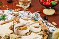 Assorted cheeses on round wooden board plate served with white wine Guda cheese, cheese grated bark of oak, hard cheese slices, Royalty Free Stock Photo