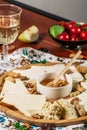 Assorted cheeses on round wooden board plate served with white wine Guda cheese, cheese grated bark of oak, hard cheese slices, Royalty Free Stock Photo