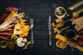 Assorted cheeses, sausages, wines, traditional spices and fresh vegetables on a wooden background. Royalty Free Stock Photo