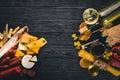 Assorted cheeses, sausages, wines, traditional spices and fresh vegetables on a wooden background. Royalty Free Stock Photo