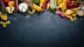 Assorted cheeses, sausages, wines, traditional spices and fresh vegetables on a wooden background. Royalty Free Stock Photo