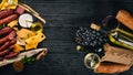 Assorted cheeses, sausages, wines, traditional spices and fresh vegetables on a wooden background. Cheese brie, blue cheese, Royalty Free Stock Photo