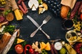 Assorted cheeses, sausages, wines, traditional spices and fresh vegetables on a wooden background. Royalty Free Stock Photo