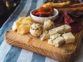 Assorted cheeses and sausages on a wooden board on a table Royalty Free Stock Photo