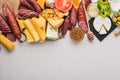 Assorted cheeses and traditional sausages and vegetables on a white wooden background. Royalty Free Stock Photo