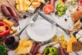 Assorted cheeses and traditional sausages and vegetables on a white wooden background. Royalty Free Stock Photo