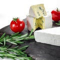 Assorted cheeses on wooden board. Camembert, cheese with blue mildew, mozzarella with tomatoes Royalty Free Stock Photo