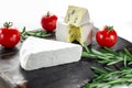 Assorted cheeses on wooden board. Camembert, cheese with blue mildew, mozzarella with tomatoes Royalty Free Stock Photo