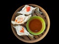 Assorted Chinese Dimsum in bamboo basket with sauce.