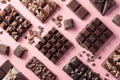 Assorted chocolate candies on pink background, top view. Chocolate pralines flat lay. Handmade chocolate candy sweets