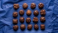 Assorted chocolates arranged in four rows on a crumpled blue background Royalty Free Stock Photo
