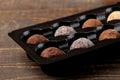 Assorted chocolates. candies of different types of chocolate on a brown wooden table Royalty Free Stock Photo