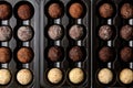 Assorted chocolates. Candy balls of different types of chocolate in a box on a brown wooden table. candy background Royalty Free Stock Photo