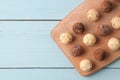 Assorted chocolates. Candy balls of different types of chocolate on a wooden board on a blue wooden table. top view Royalty Free Stock Photo