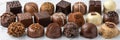 Assorted chocolates in various shapes, sizes, flavors attractively displayed against simple backdrop