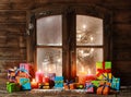 Assorted Christmas Presents and Candles at Window Royalty Free Stock Photo