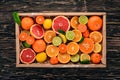 Assorted citrus fruit in a wooden box. Orange, tangerine, grapefruit, lemon. On a wooden background. Royalty Free Stock Photo