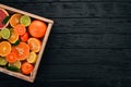 Assorted citrus fruit in a wooden box. Orange, tangerine, grapefruit, lemon. On a wooden background. Royalty Free Stock Photo