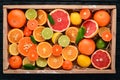 Assorted citrus fruit in a wooden box. Orange, tangerine, grapefruit, lemon. On a wooden background. Royalty Free Stock Photo