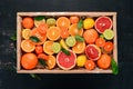 Assorted citrus fruit in a wooden box. Orange, tangerine, grapefruit, lemon. On a wooden background. Royalty Free Stock Photo