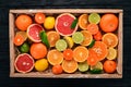 Assorted citrus fruit in a wooden box. Orange, tangerine, grapefruit, lemon. On a wooden background. Royalty Free Stock Photo