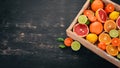 Assorted citrus fruit in a wooden box. Orange, tangerine, grapefruit, lemon. On a wooden background. Royalty Free Stock Photo