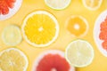 Assorted citrus sliced fruit levitating above yellow background