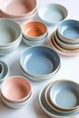 Assorted Collection of Colorful Ceramic Bowls and Plates on White Surface Royalty Free Stock Photo