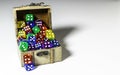 Assorted colored dice in old wood box on white
